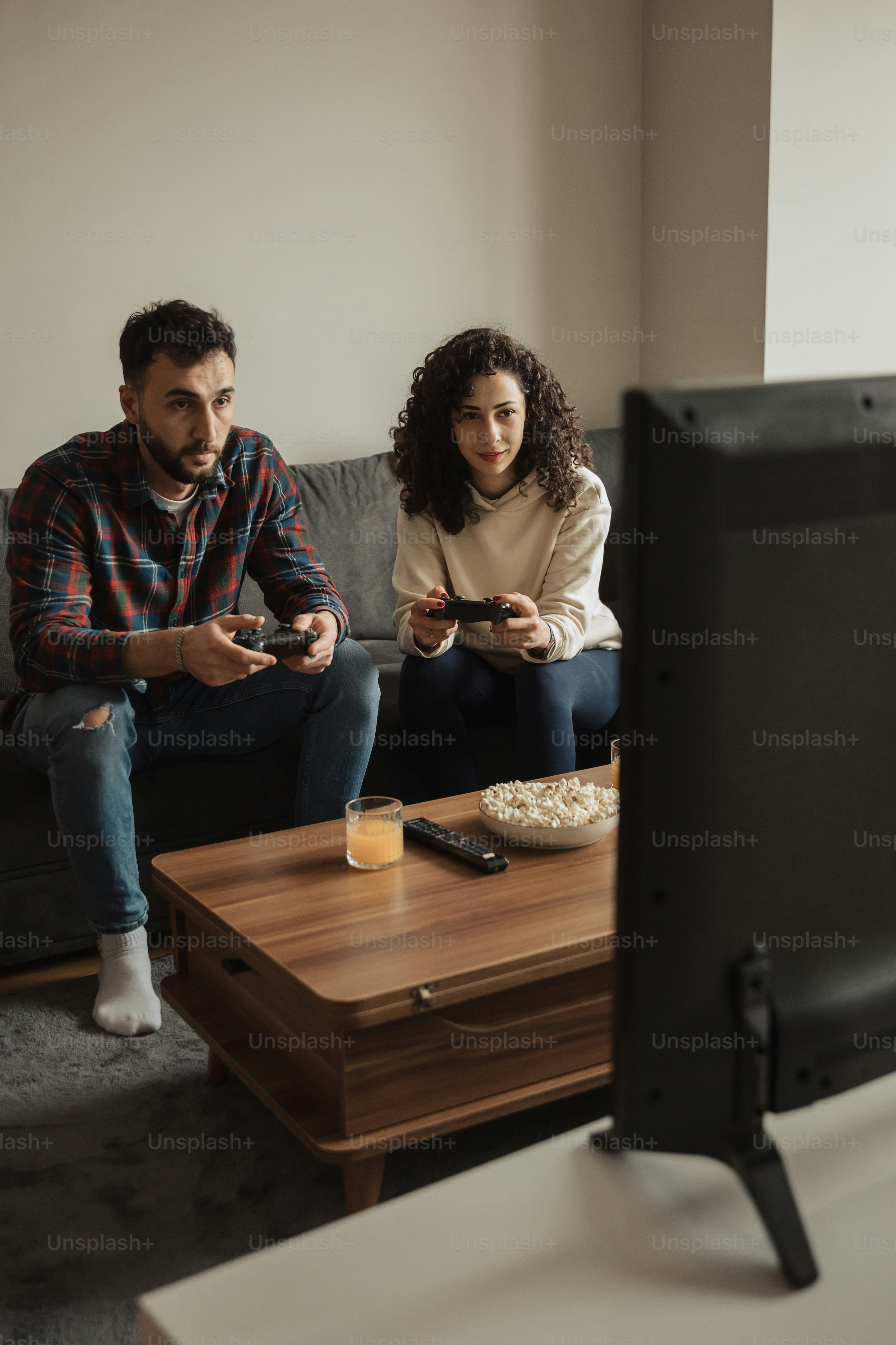 a man and a woman sitting on a couch playing a video game